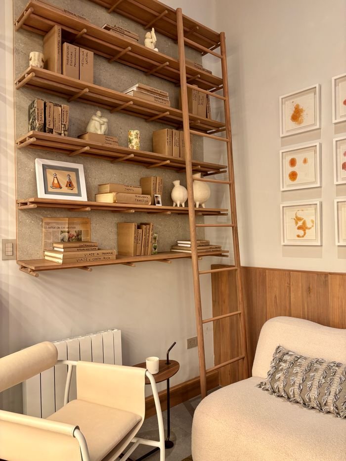 Bright and cozy minimalist living room with wooden shelves and neutral decor.