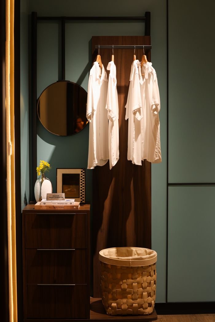 Stylish bedroom corner showing organized wardrobe space with hanging shirts.